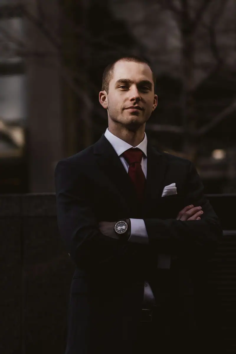 Man in a dark suit with arms crossed