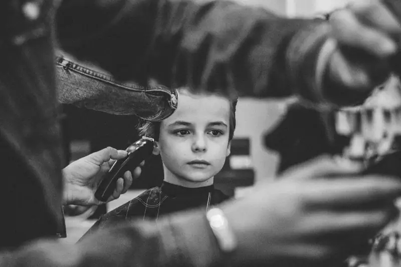 Black and white close-up of a boy's haircut