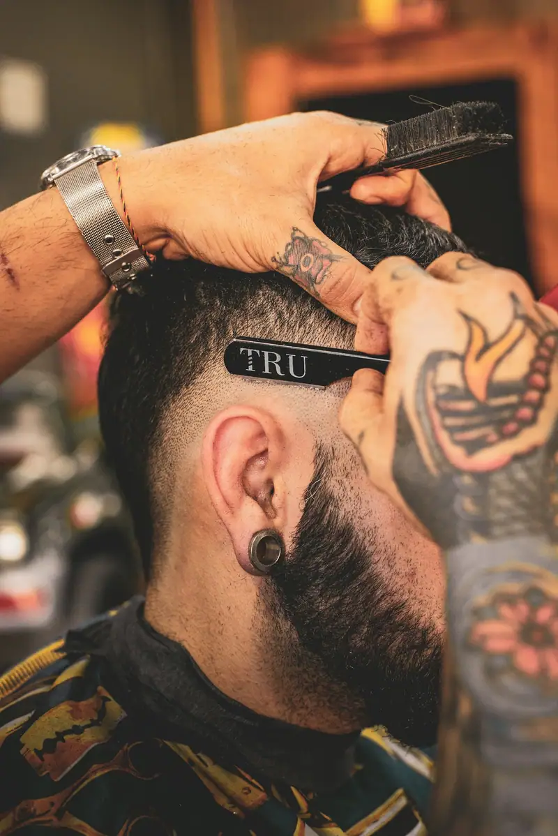 Barber shaping a fade with a razor