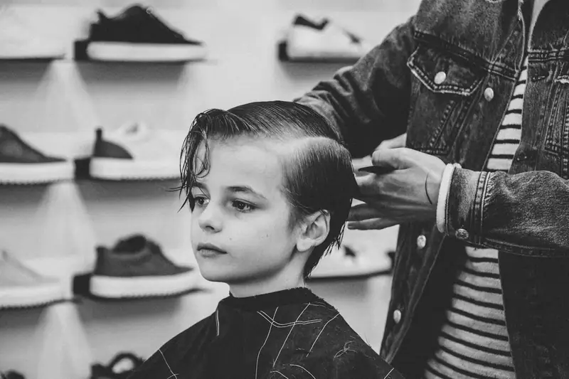 Black and white photo of a boy getting a haircut
