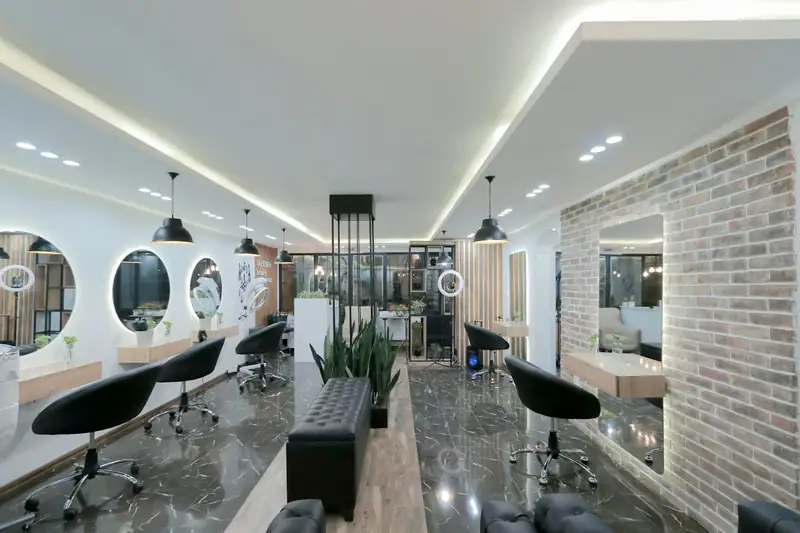Modern salon with brick wall, round mirrors and black chairs