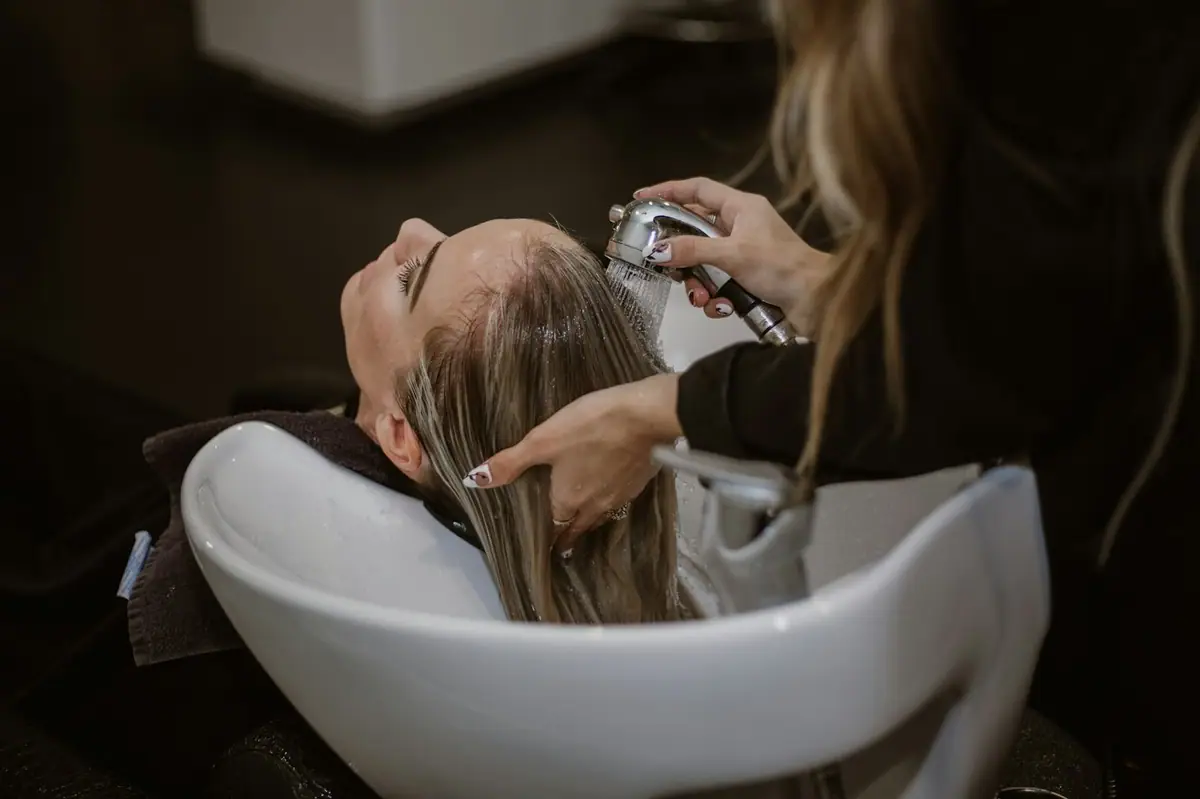 Client having hair washed at a salon basin