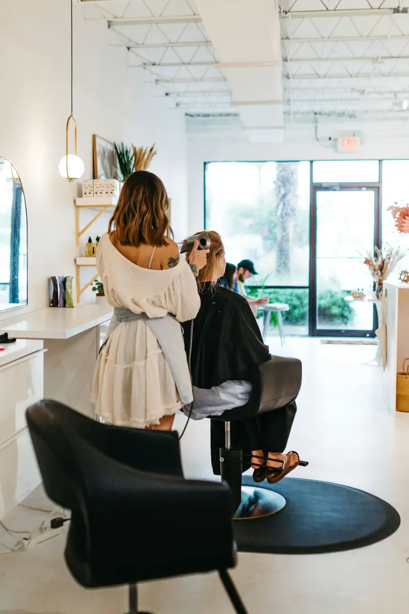 Bright airy salon with a stylist working at a chair