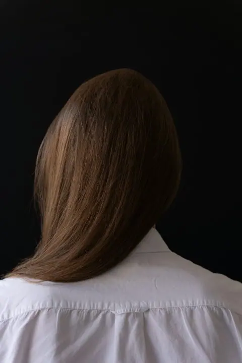 Smooth brown hair, black backdrop